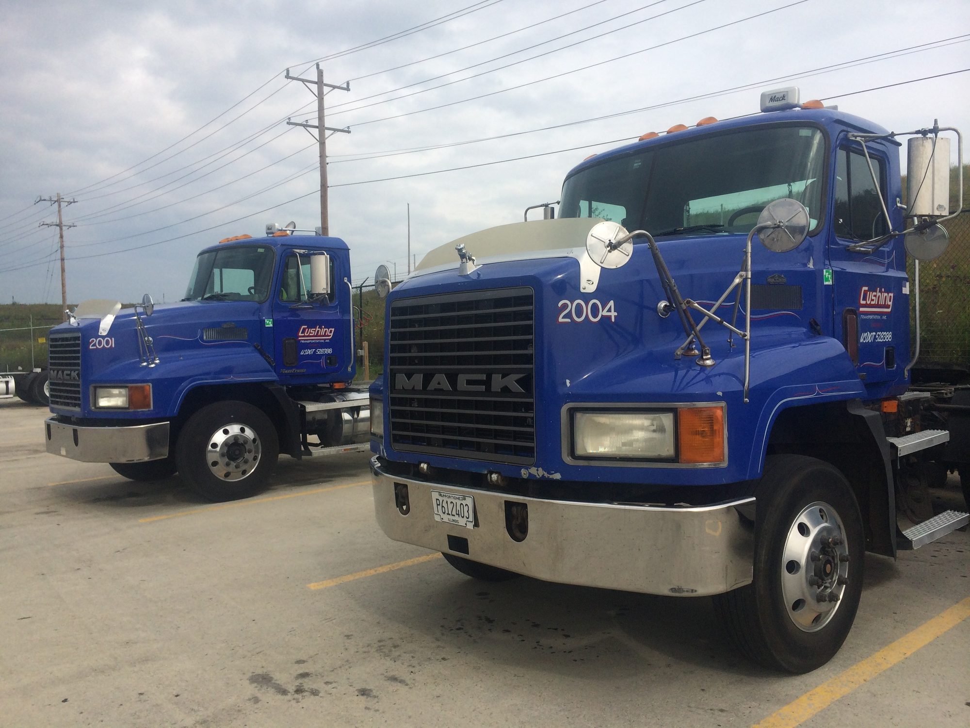 Two Cushing Mack tractors parked in the yard, unit 2004 nearest the camera